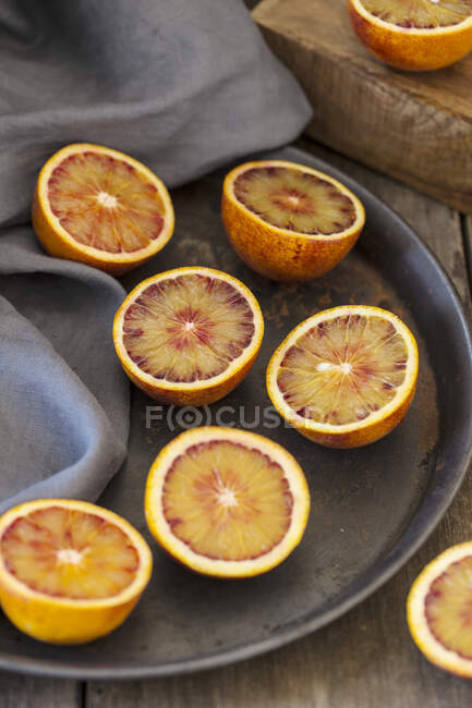 Halved grapefruits on metal plate with cloth — Stock Photo
