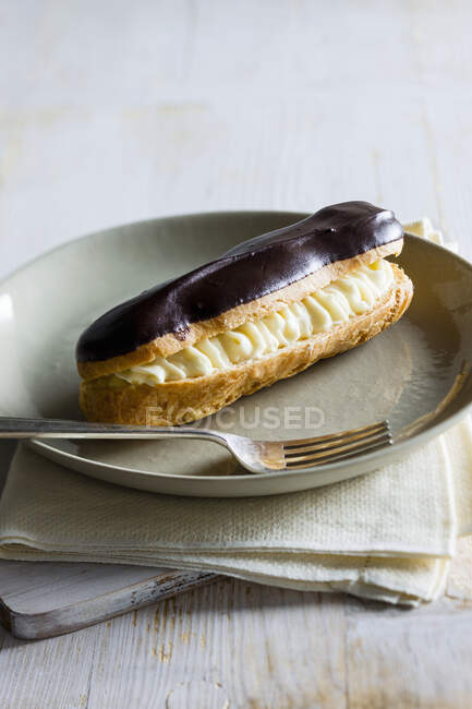 Eclair with chocolate icing — Stock Photo