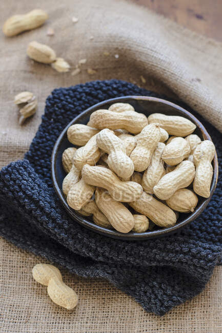 Peanuts in a bowl on a wooden background — Stock Photo