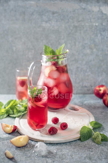 Raspberry and peach iced tea with mint and ice — Stock Photo