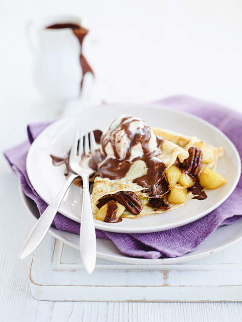Crepes with chocolate sauce, pears and pecans — Stock Photo
