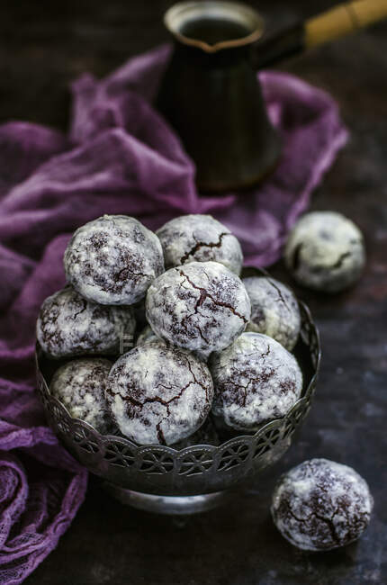 Chocolate balls cookies in metal bowl with cezve on background — Stock Photo