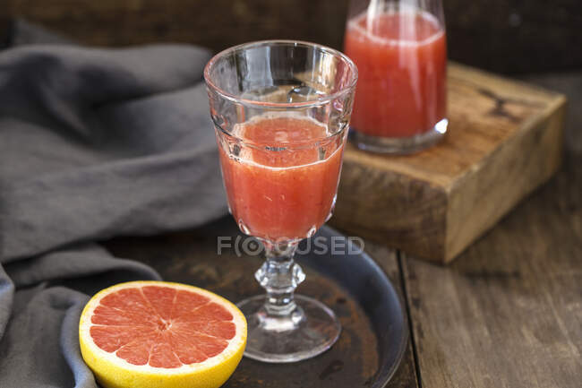 Grapefruitsaft und eine halbe Grapefruit — Stockfoto