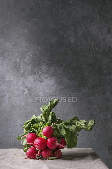 Куча редис с листьями на столе — стоковое фото
