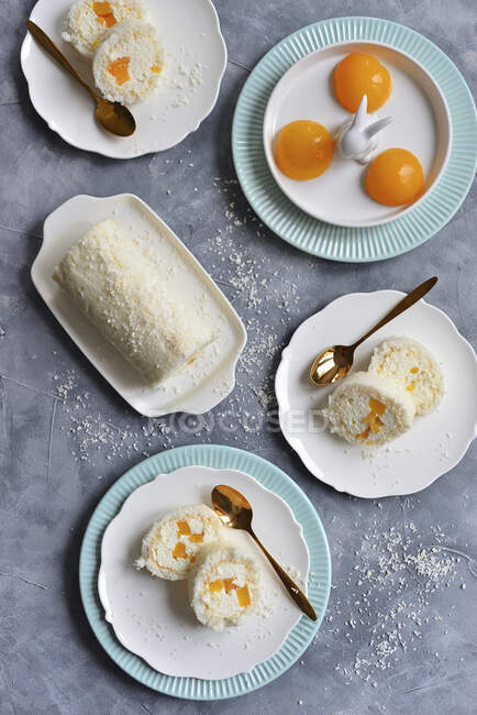 Meringue coconut roll with whipped cream and peaches — Stock Photo