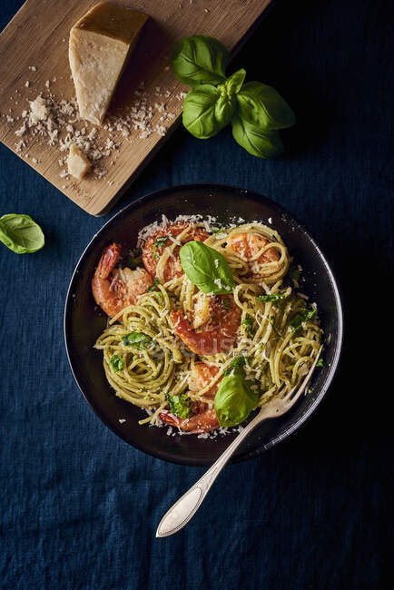 Primer plano de deliciosos espaguetis con pesto y gambas - foto de stock