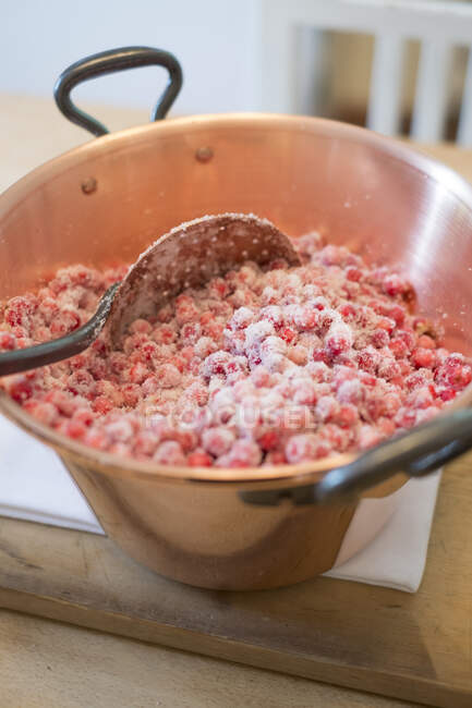 Ягодное варенье из Лингона, сырые ягоды лингона в кастрюле с сахаром — стоковое фото