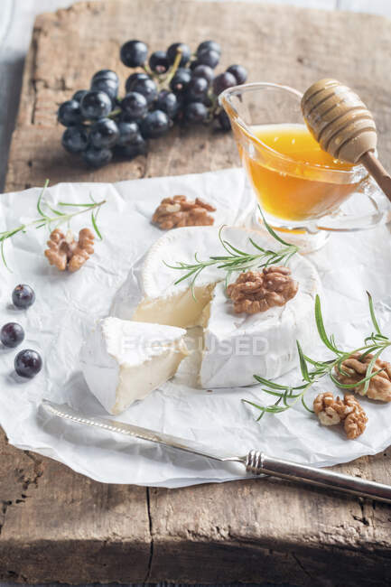 Brie cheese with nuts, honey and rosemary — Stock Photo
