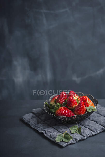 Fresh strawberries in metal bowl on dark background — Stock Photo