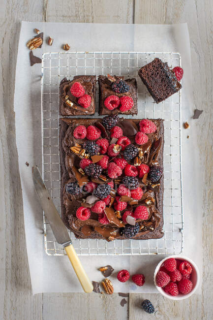 Chocolate tarybake with chocolate buttercream icing, chocolate and pecan bark and berries — Stock Photo