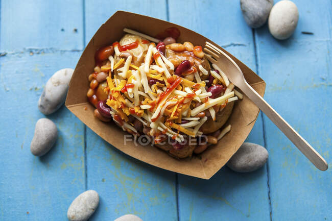 Fried potatoes with baked beans and cheese — Stock Photo