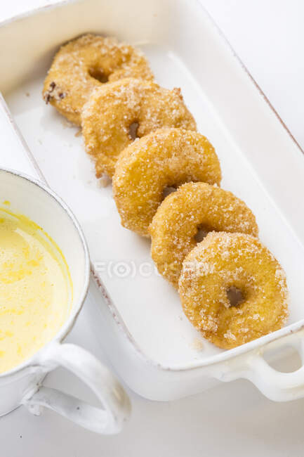Яблочные пончики с ванильным соусом — стоковое фото