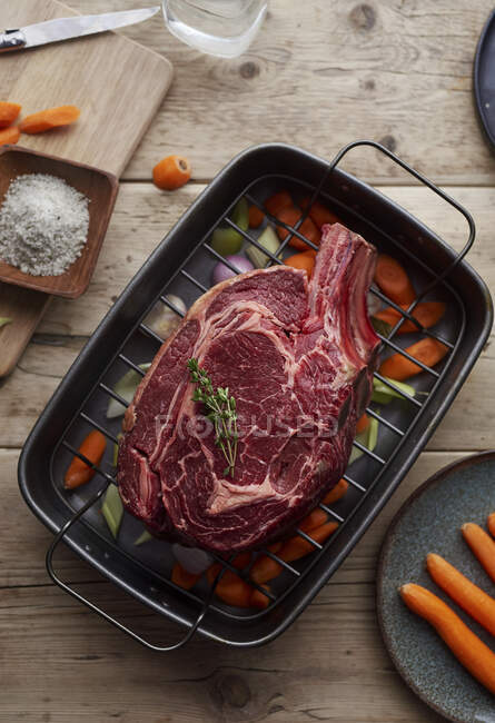 Côtes de bœuf et légumes crus dans une boîte à rôtir — Photo de stock