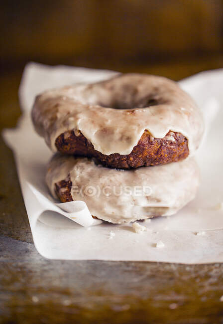 Zwei glutenfreie Donuts mit Chai-Zuckerguss auf Papier — Stockfoto