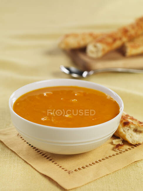 Carrot soup with bread sticks — Stock Photo