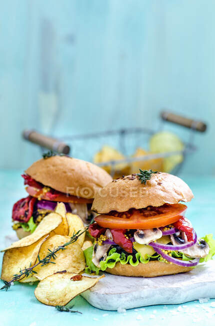 Hambúrgueres e batatas fritas em um fundo azul — Fotografia de Stock