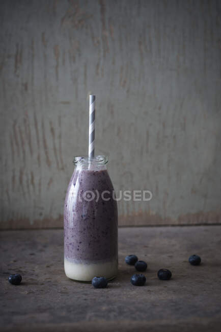 Vegan cashew nut and blueberry smoothie in a glass bottle — Stock Photo