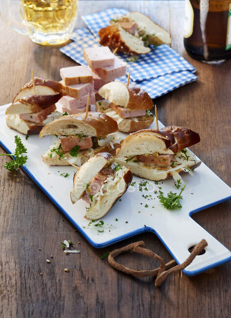 Spuntino di pane di liscivia con manzo e polpettone di maiale su una tavola di ceramica — Foto stock