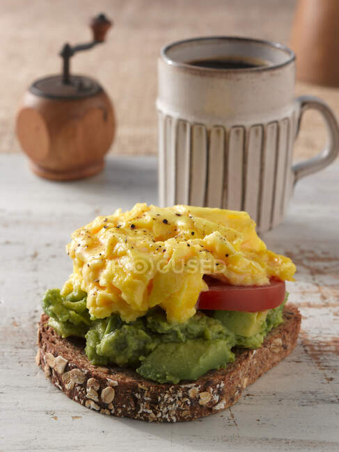 Bread with scrambled eggs, tomato slice and avocado — Stock Photo