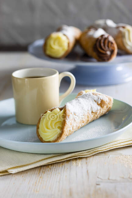 Cannole with Vanilla and cup of tea — Stock Photo