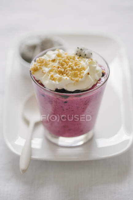 Pudding with wild berries, whipped cream, nuts and dragon fruit — Stock Photo