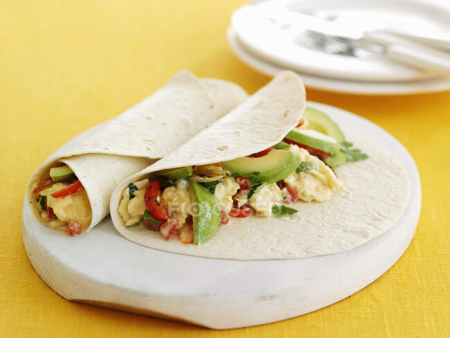 Wraps with scrambled eggs and avocado on white board — Stock Photo
