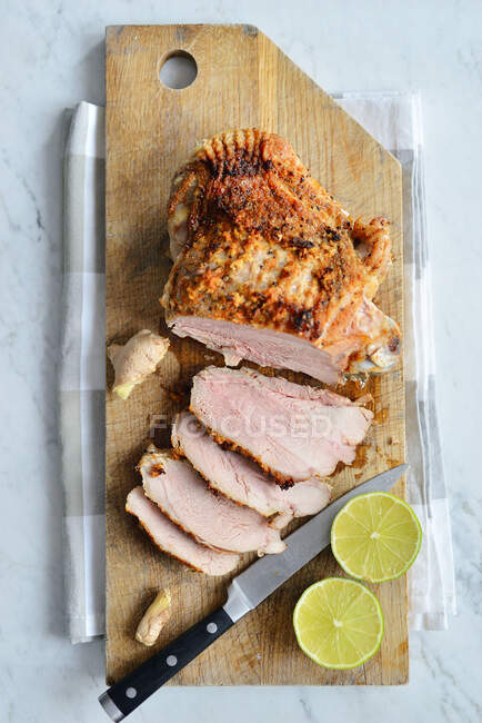 Roasted chicken breast, sliced, on chopping board — Stock Photo