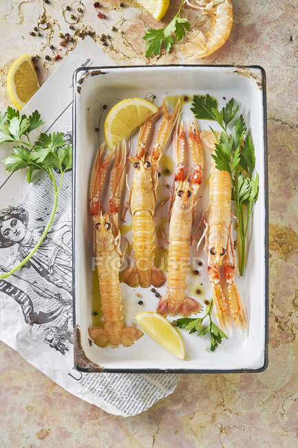 Langoustines in oventray with lemon, parsley and olive oil — Stock Photo