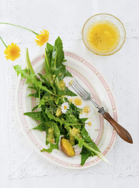 Салат из одуванчиков с картофельным винегретом — стоковое фото