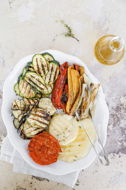 Dish with grilled vegetables, courgettis, aubergines, peppers, tomatoes, spring onions and cheese — Stock Photo