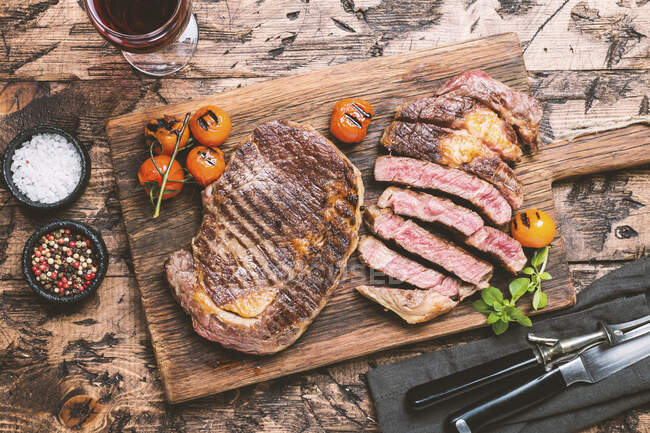 Steak de boeuf moyen et rare Ribeye avec assaisonnements et vin rouge — Photo de stock