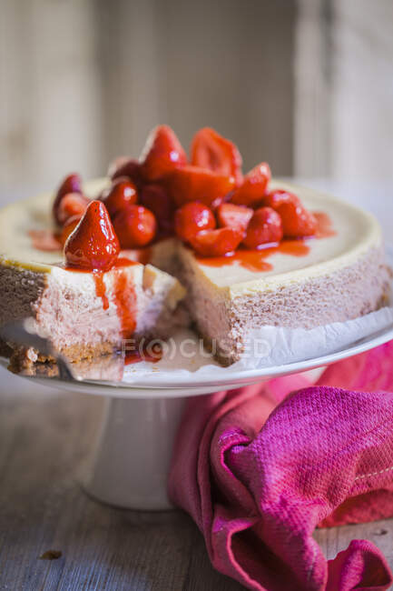 Strawberry cheesecake on a cake stand, sliced — Stock Photo