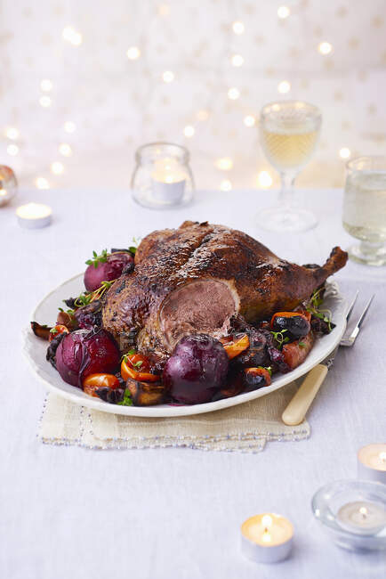 Roast duck with plums and roasted vegetables: tomatoes, carrots, sweet potato and onions — Stock Photo
