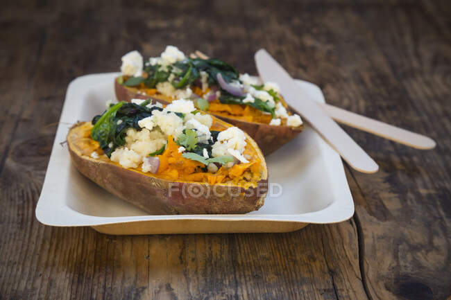 Stuffed sweet potatoes with spinach, red onions, couscous, feta cheese and coriander — Stock Photo