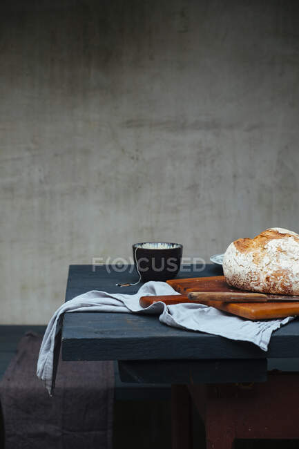 Una natura morta con una pagnotta di pane e tazze da tè su un tavolo — Foto stock