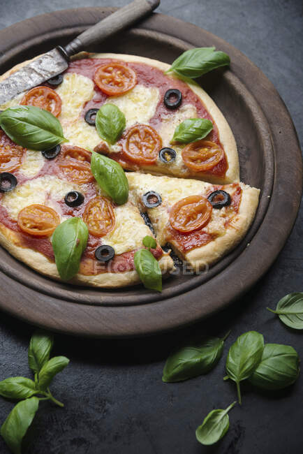 Pizza vegana de coliflor con tomates, aceitunas, albahaca y queso vegano - foto de stock