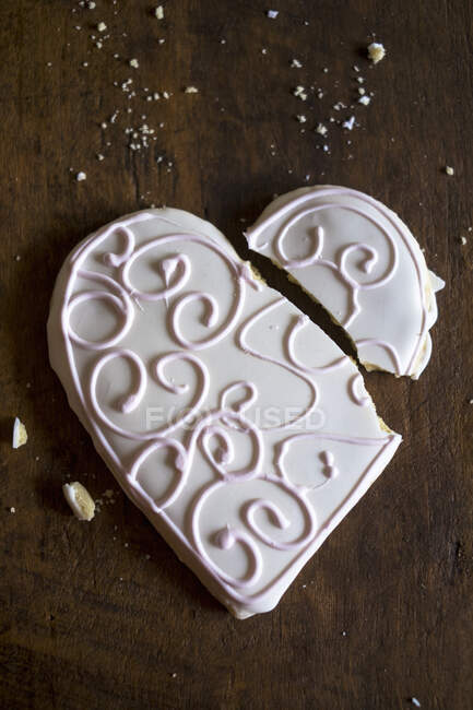 A broken, heart-shaped biscuit with icing — Stock Photo