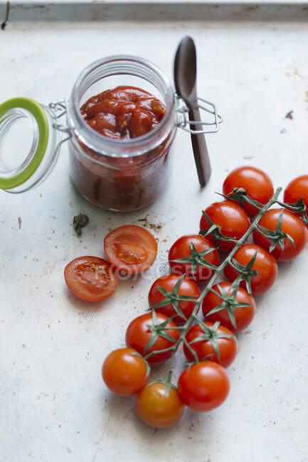 Tomato sauce in a glass and fresh cherry tomatoes — Stock Photo