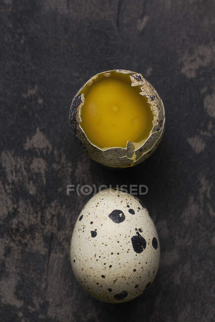 Два перепелиных яйца: цельное и треснутое — стоковое фото