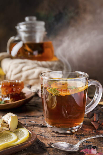 Glass cup of hot tea with mint, honey, ginger and lemon — Stock Photo
