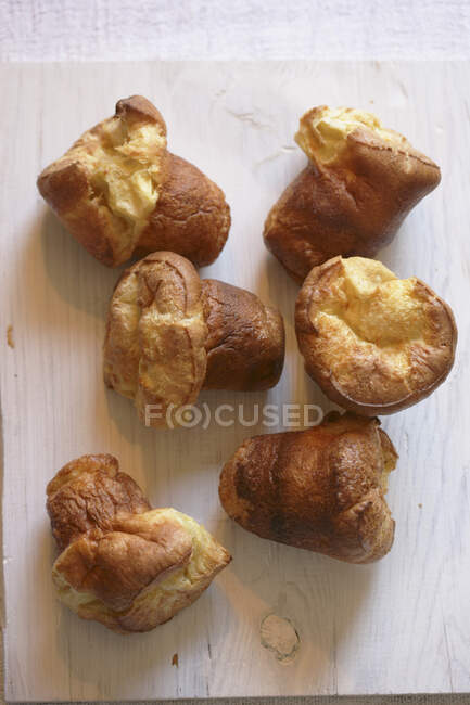 Croissants frais cuits au four sur fond de bois blanc — Photo de stock