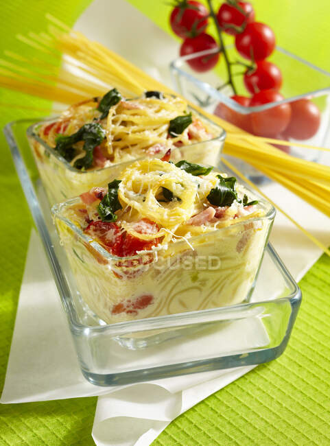Colorful baked pasta nest with spinach, boiled ham and Parmesan — Stock Photo
