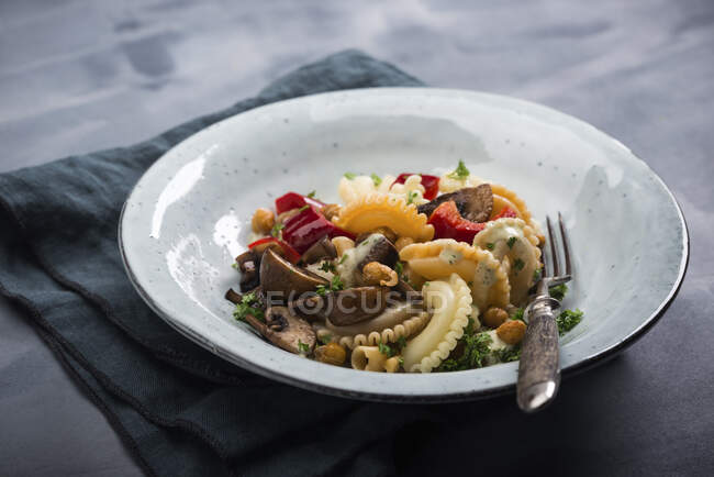 Веганский салат из теплая пасты с перцем, грибами и жареным горохом — стоковое фото