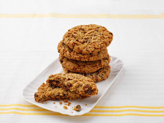 Biscuits à l'avoine avec raisins secs sur plaque blanche — Photo de stock