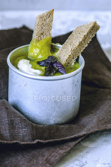 Pea soup with bread strips and basil — Stock Photo