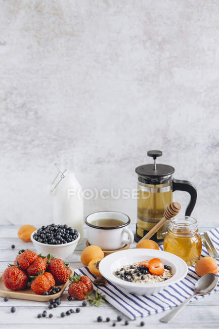 Крупный план вкусных мюсли с фруктами, медом и чаем — стоковое фото