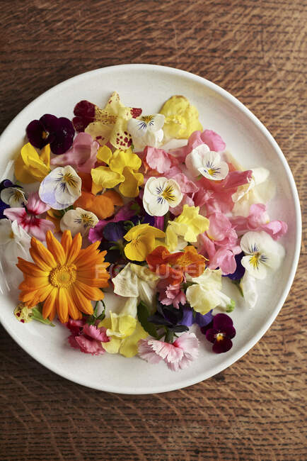 Съедобные цветы на тарелке видны сверху — стоковое фото