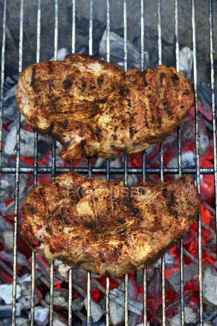 Bistecche di maiale su un barbecue — Foto stock