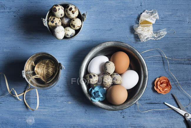 Ассортимент яиц, элементов декора на деревенском синем деревянном фоне — стоковое фото