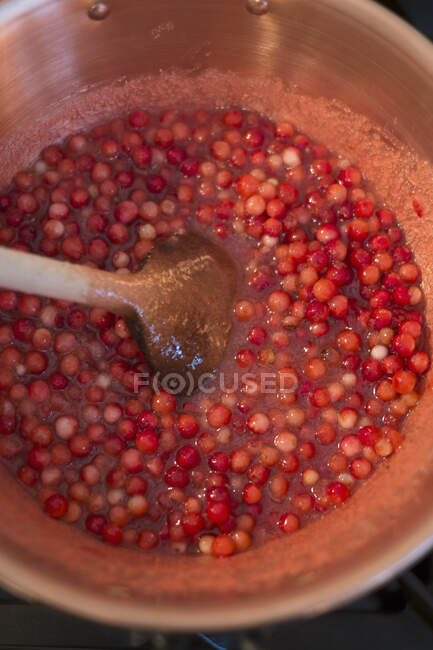 Ягодное варенье Лингон готовится, ягоды лингона нагреваются в кастрюле — стоковое фото